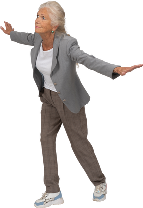 Front view of an old lady in suit standing with outstretched arms