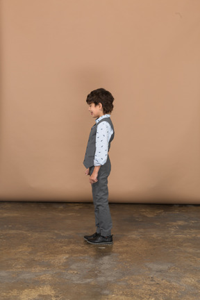 Cute boy in suit standing in profile