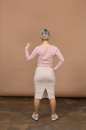 Vista posteriore di una donna in abiti casual che mostra le piccole dimensioni di qualcosa