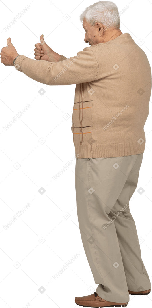 Side view of an old man in casual clothes showing thumbs up