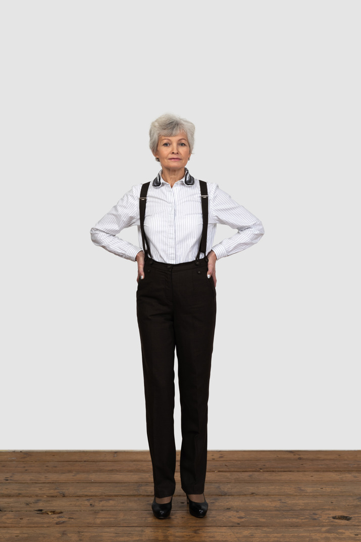 Full-length of an old female in suspenders putting hands on hips
