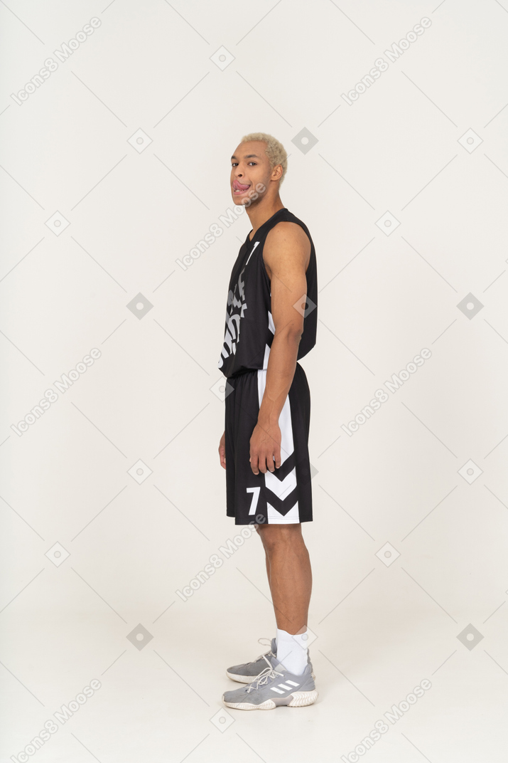 Three-quarter view of a young male basketball player licking lips