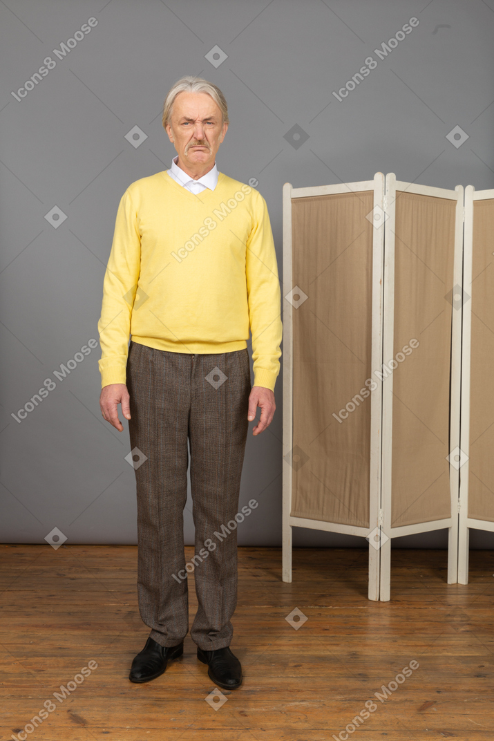 Front view of an old displeased man standing still