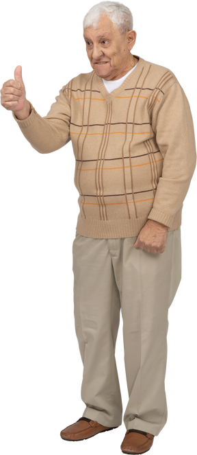 Vista frontale di un vecchio felice in abiti casual che mostra il pollice in su
