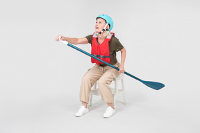 Mature woman in helmet sitting and learning how to paddle