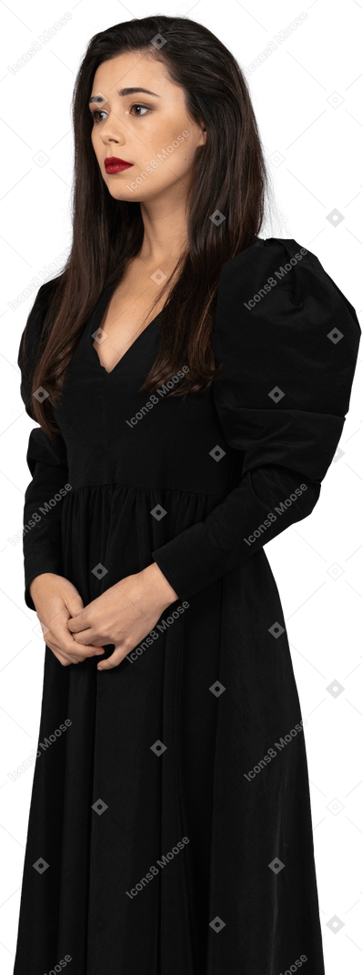 一位年轻的女士穿着一件黑色的连衣裙，手牵着手的四分之三的视图