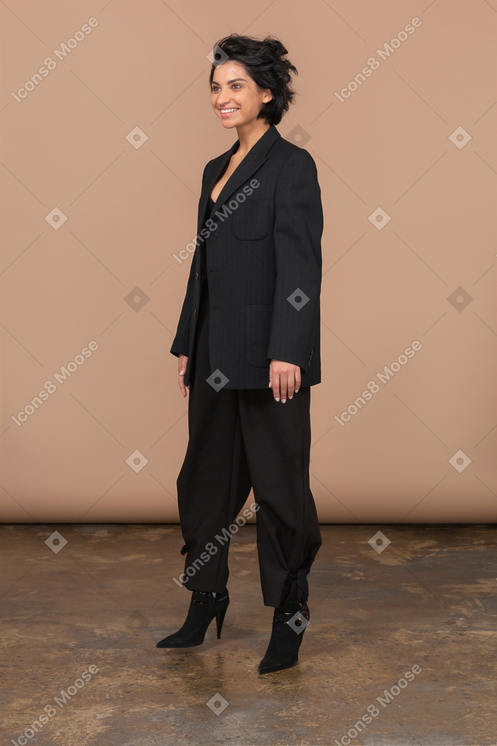 Three-quarter view of smiling businesswoman wearing black suit