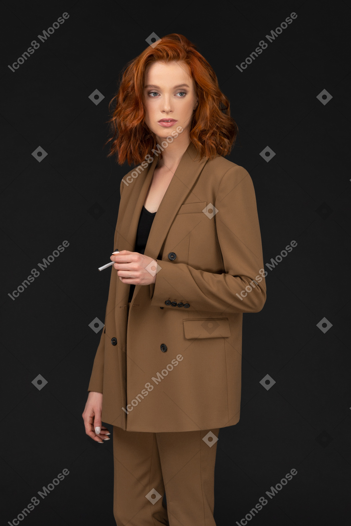 Young woman in a suit holding a cigarette