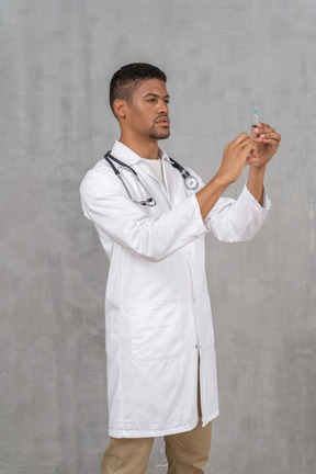 注射器を準備する男性医師