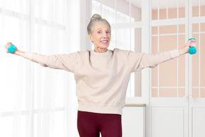 Elderly woman exercising with two small dumbbells