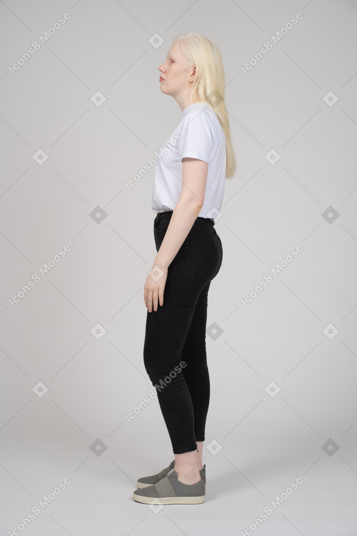 Vista lateral de una mujer joven en ropa casual mirando a un lado