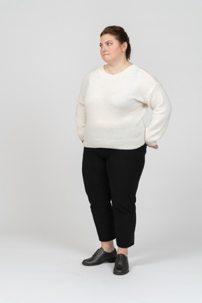 Plump woman in casual clothes standing in profile