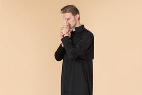 Catholic priest praying with eyes closed using prayer beads