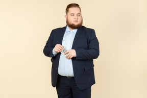 A plus-size man in a black costume with dollar bills in his hands