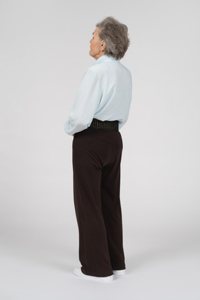 Back view of an old woman standing straight