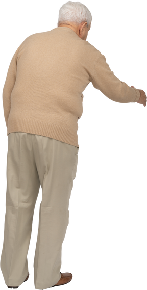 手を振るカジュアルな服装の老人の背面図