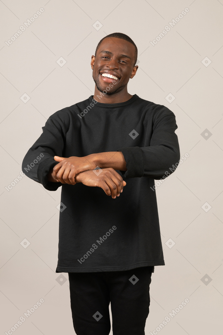 Young man smiling and pulling up sleeve