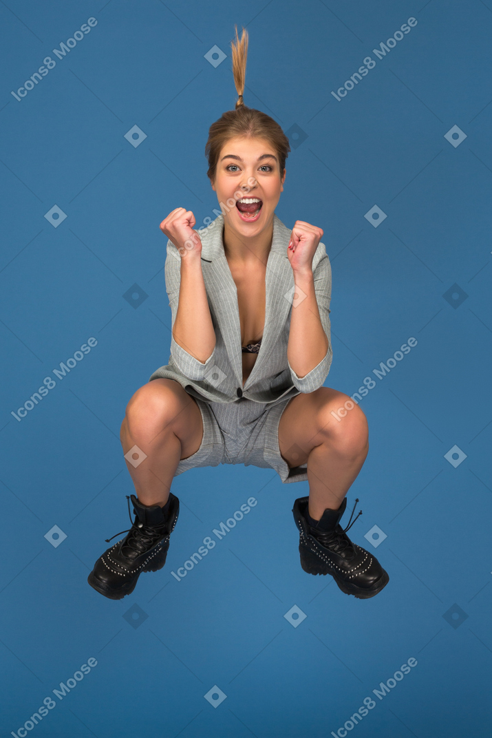 Thrilled young woman jumping high