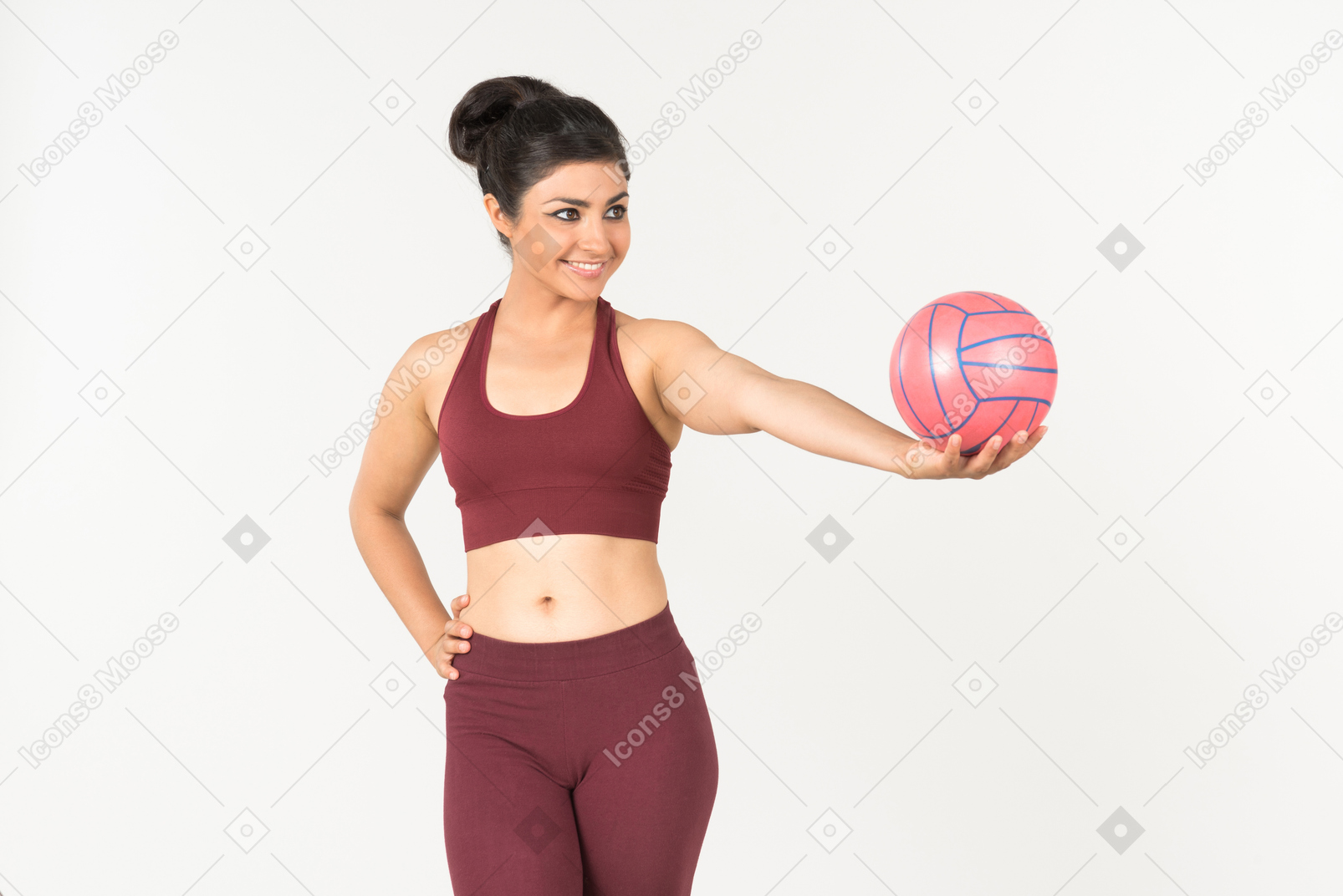 Молодая индийская женщина в спортивной одежде держит розовый шар