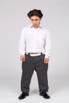 Young man in business casual clothes looking down