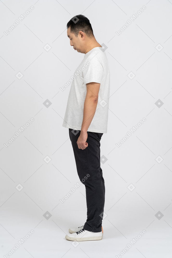Vista lateral de um homem em roupas casuais, abaixando a cabeça
