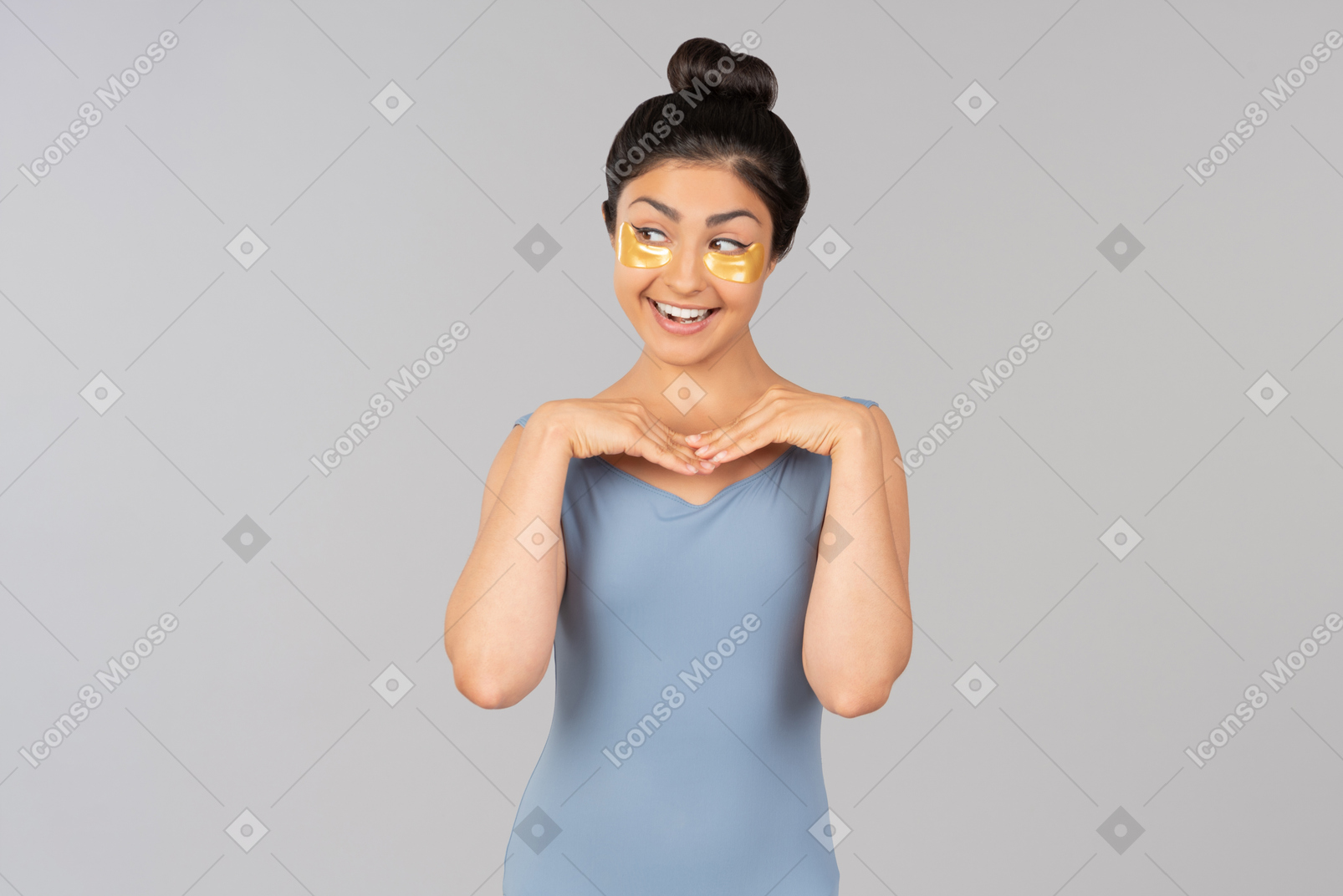 Laughing young indian woman with eye patches on touching her face