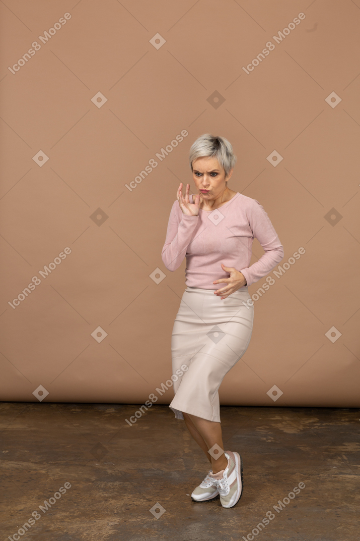 Vista frontal de uma mulher com roupas casuais fazendo caretas