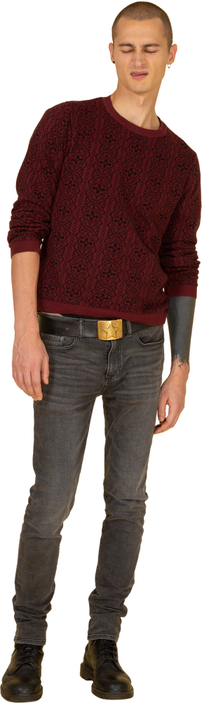 赤いセーターを着た若い顔をゆがめた男の正面図