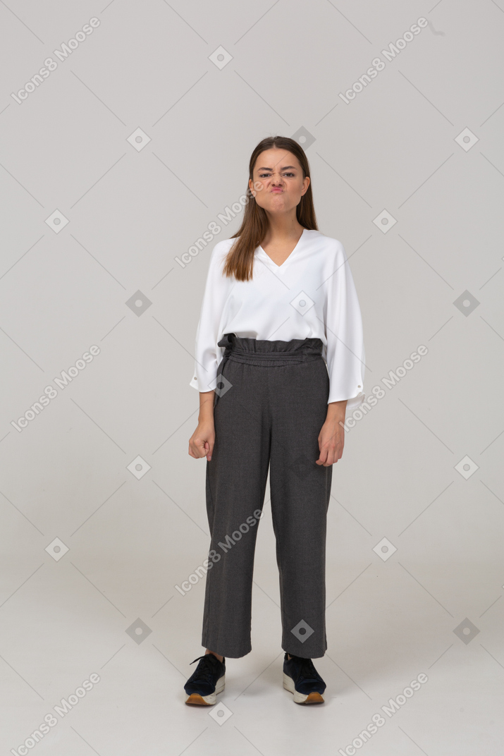 Vista frontale di una giovane donna con una smorfia in abiti da ufficio office