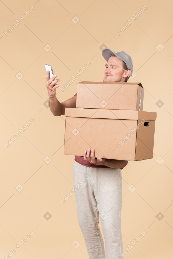 Delivery guy holding box and writing something down in the folder