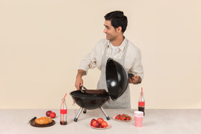 Smiling young caucasian man cooking bbq