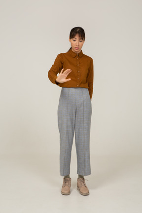Front view of a young asian female in breeches and blouse outstretching her arm