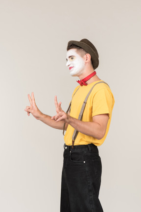 Male clown looking down and touching his forehead