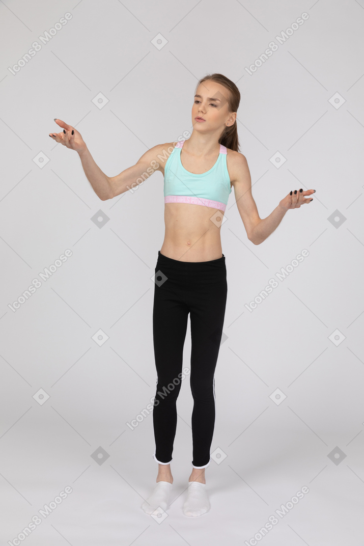 Vista lateral de una jovencita en ropa deportiva levantando la mano y argumentando