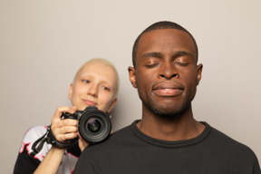 Femme souriante avec caméra regardant l'homme