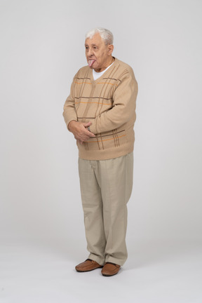 一位穿着休闲服的老人露出舌头的正面图