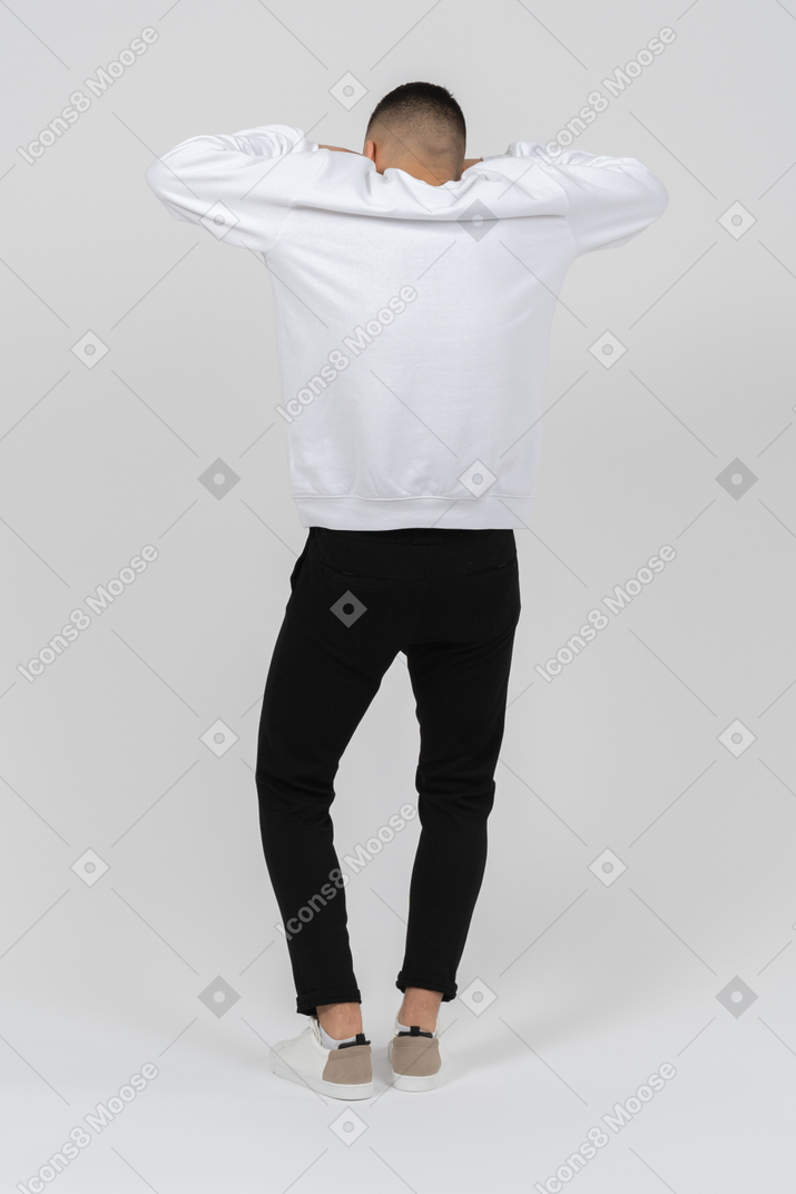Vista traseira de um homem em roupas casuais com as mãos na cabeça