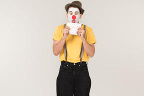 Male clown licking envelope