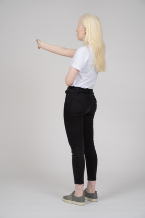 Vista posteriore di una donna dai capelli lunghi con il braccio proteso