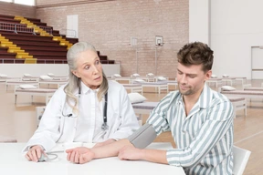 Female doctor measuring male patient's blood pressure