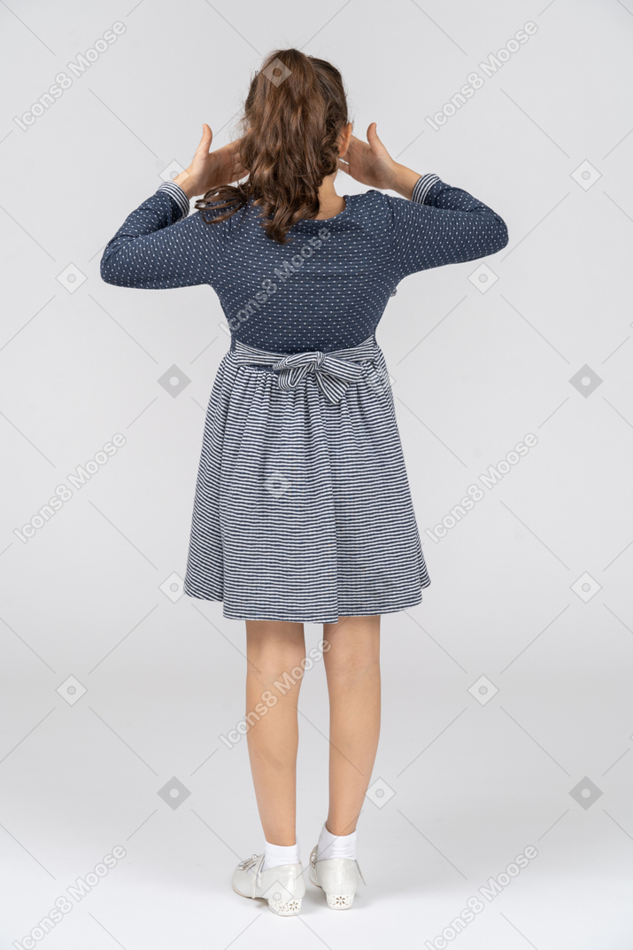 Vista traseira de uma garota cobrindo os olhos com as mãos