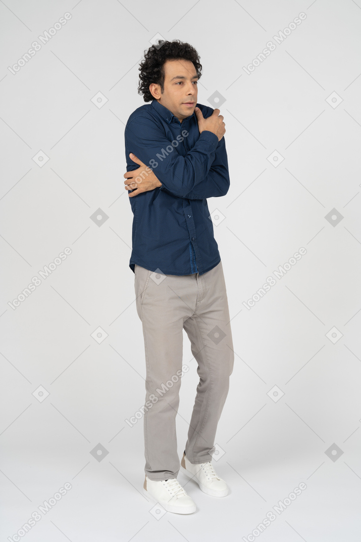 Vorderansicht eines mannes in freizeitkleidung, der mit verschränkten armen posiert