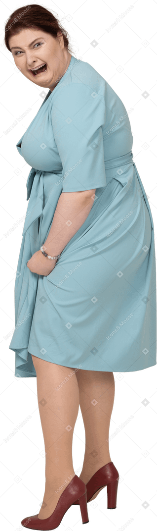 Вид сбоку испуганной женщины в синем платье