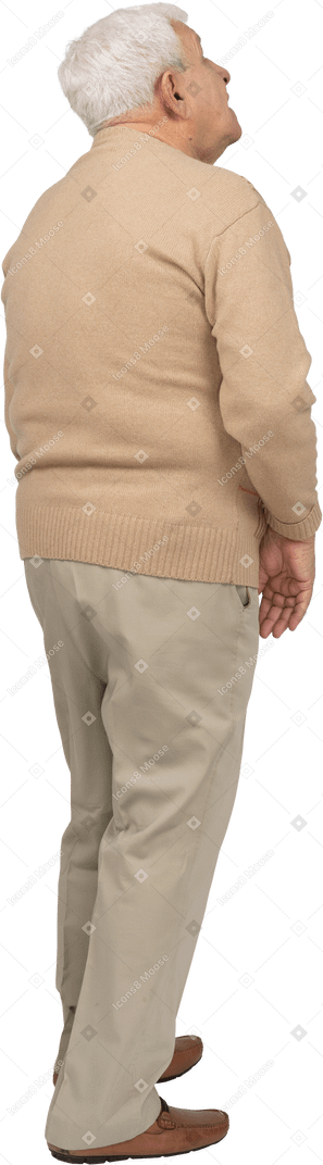 見上げるカジュアルな服装の老人の背面図