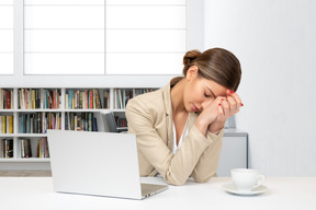 A woman sitting at a table with a laptop in front of her