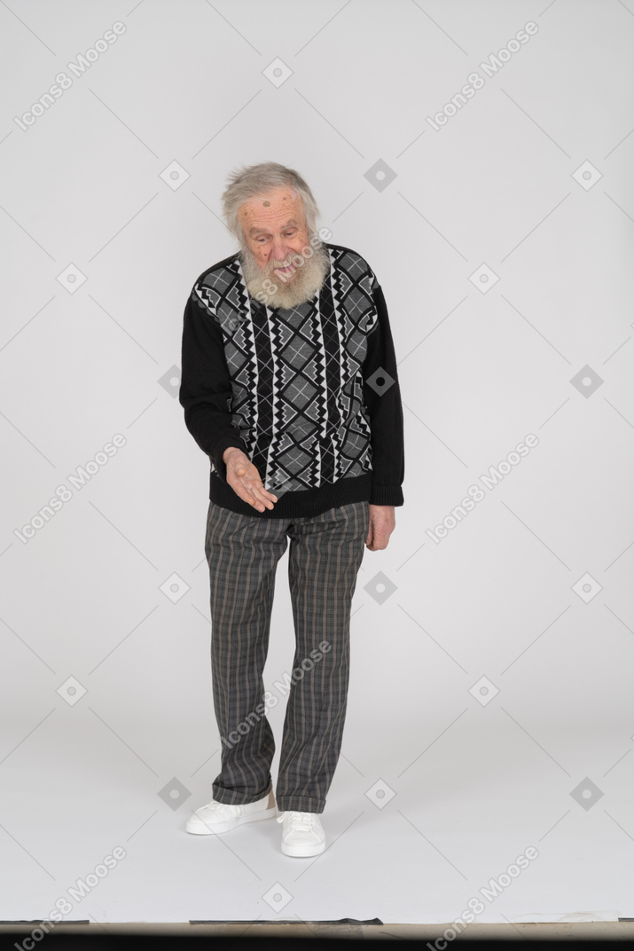 Elderly man looking down and holding out his hand