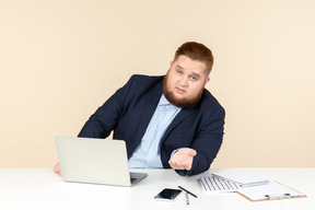 Joven con sobrepeso sentado en el escritorio y le gusta hablar de algo