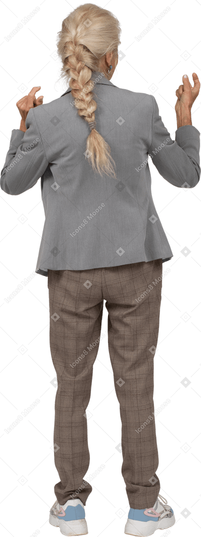 Back view of an old lady in suit standing with hands up