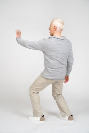 Rear view of man showing stop gesture