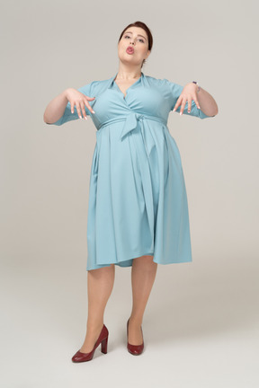 Vista frontal de uma mulher de vestido azul fazendo caretas